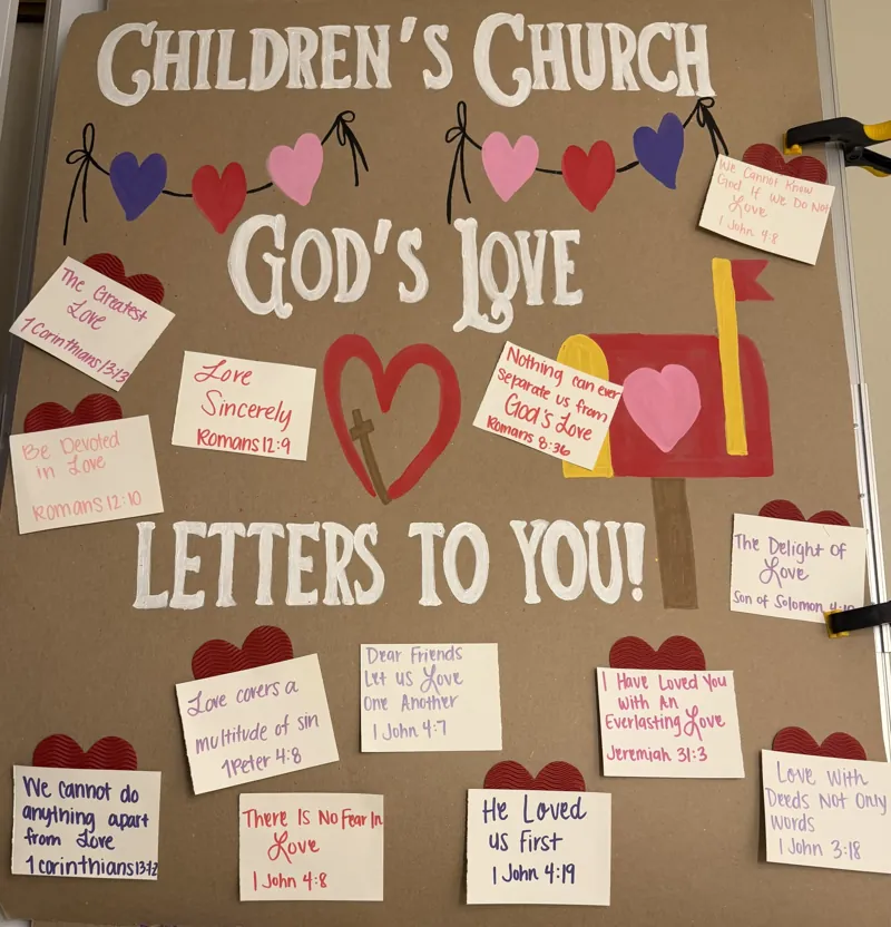 Tall hand-painted children's church banner reading God's Love Letters to You with a heart garland, a red mailbox and painted envelopes carrying Bible verses