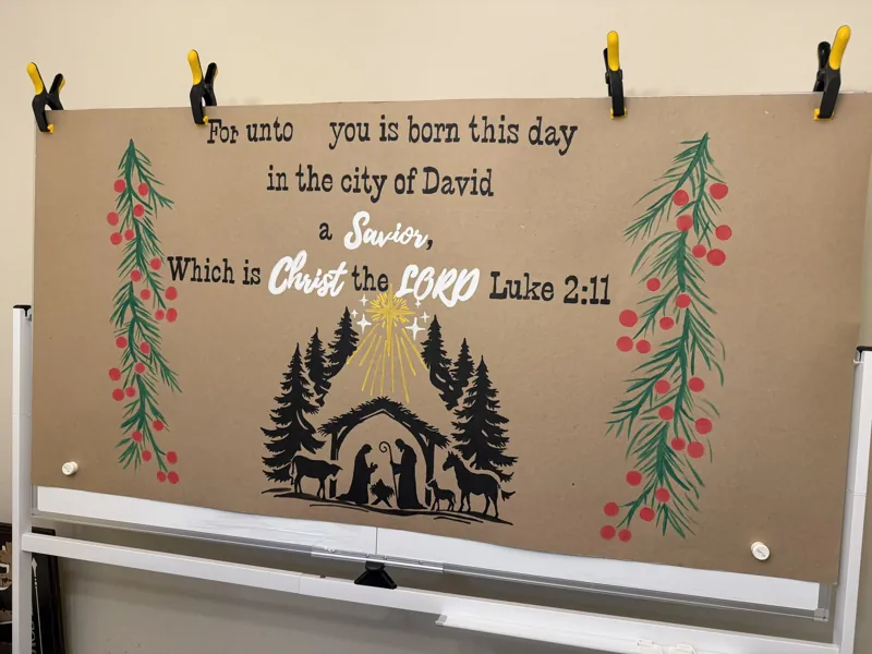 Hand-painted Christmas scripture banner of Luke 2:11 with a nativity silhouette and pine branches with red berries