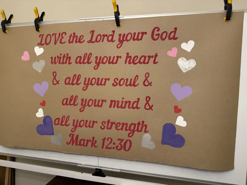 Hand-painted scripture banner of Mark 12:30 in red script with pink, purple and white hearts